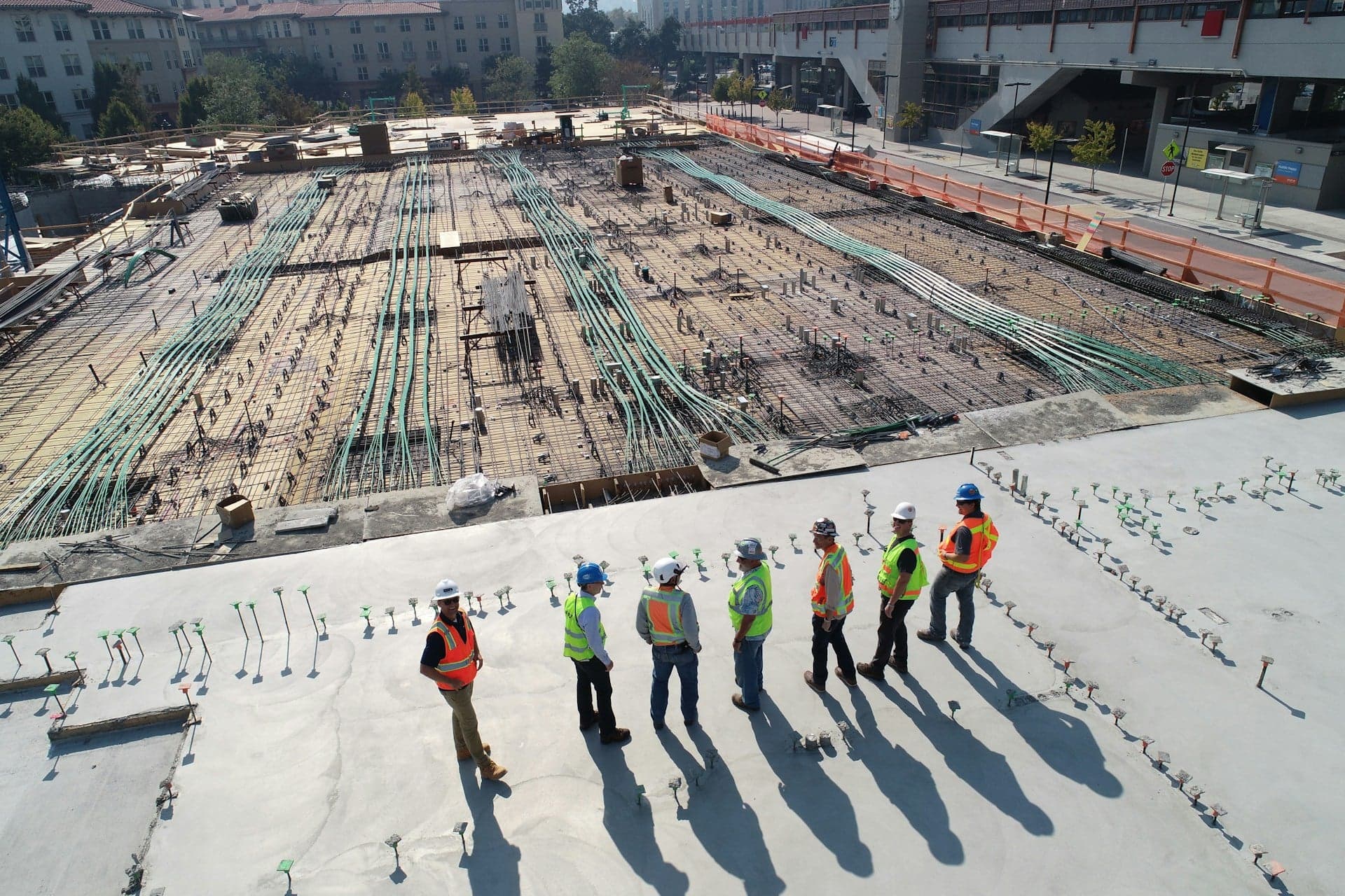 Construction site with five men standing and chatting